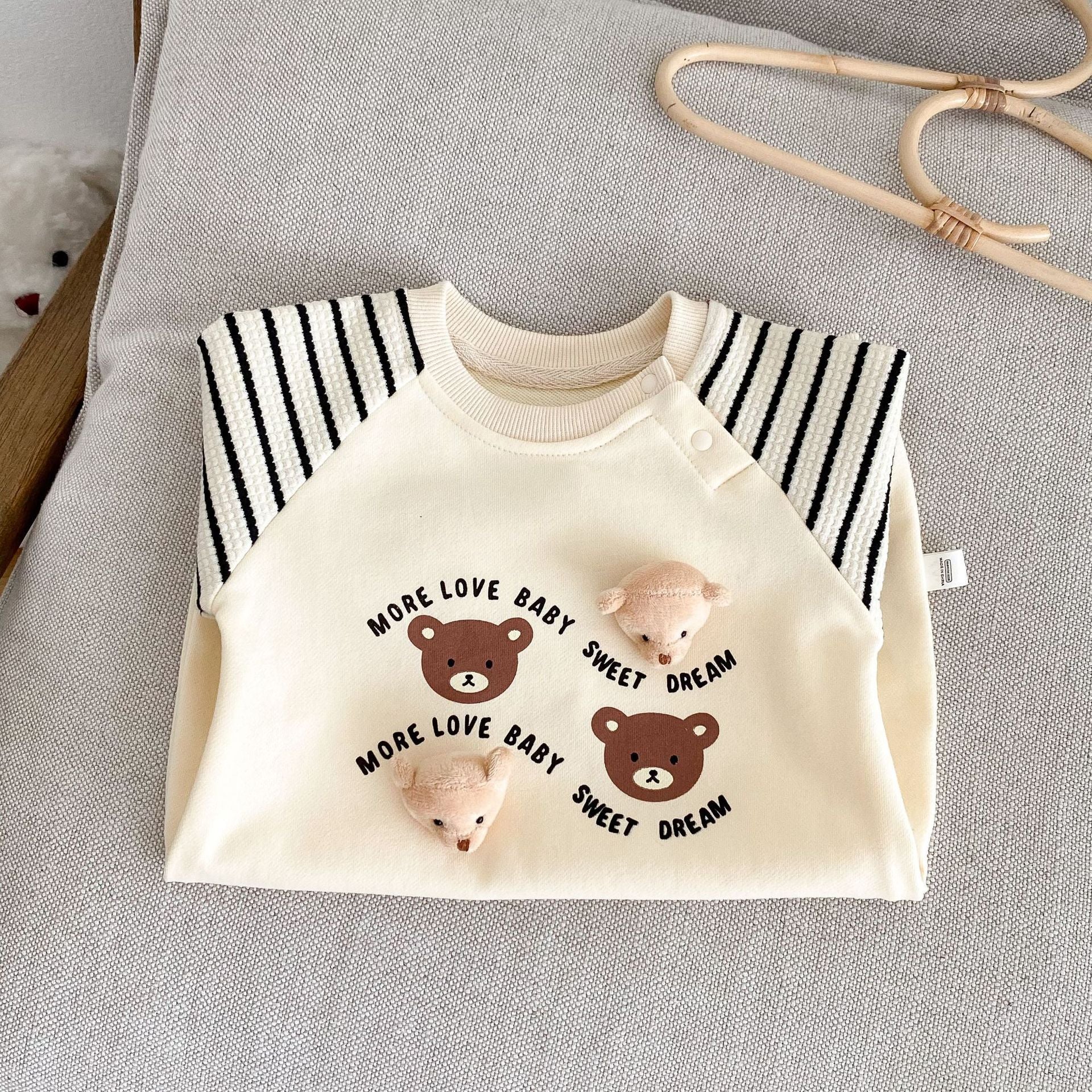 三匹のテディベアプリントが並んだアプリコットカラー長袖ベビーカバーオールの胸元アップ
