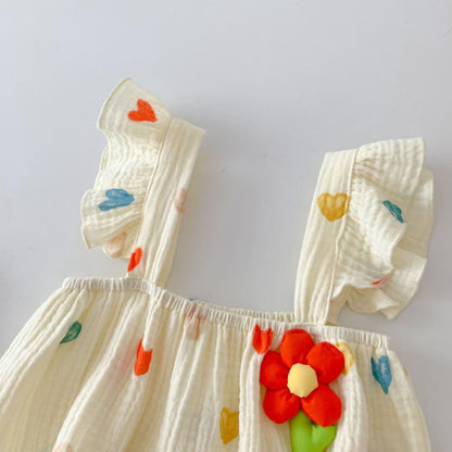 立体フラワーとスリングストラップのディテールが分かるベビーロンパース上部
