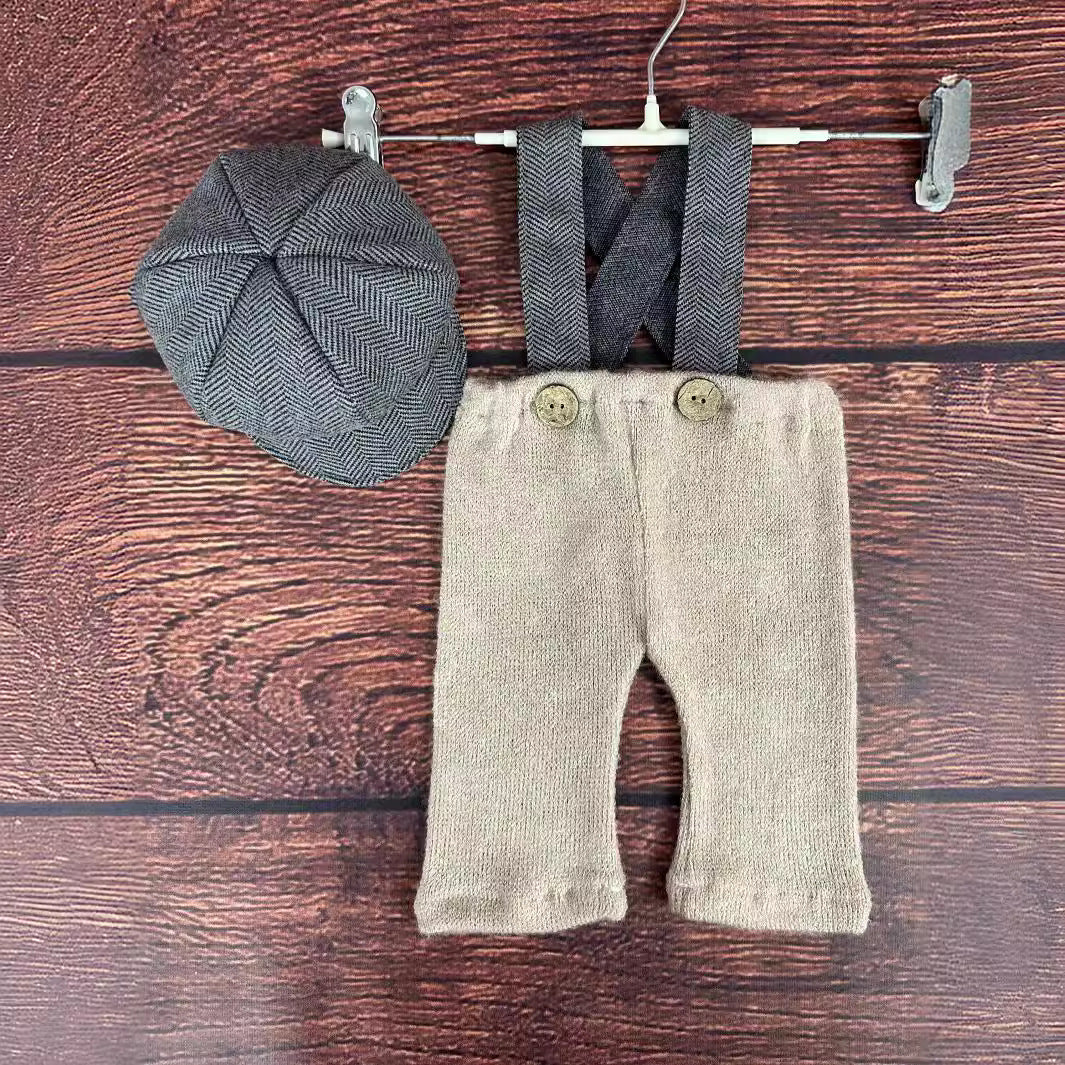 背景小物と組み合わせたグレーオーバーオール着用イメージの新生児フォトシーン
