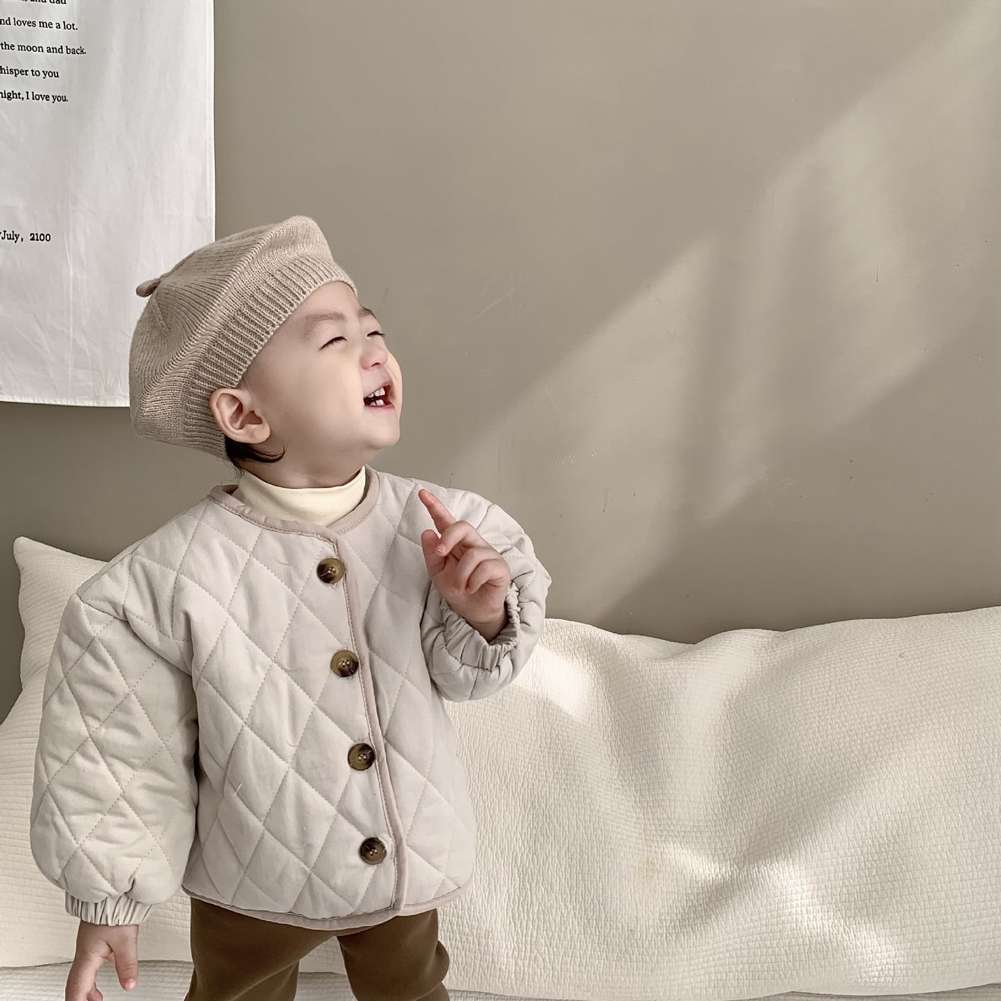 アプリコットカラーのトップスに羽織った子ども用キルティングジャケットの着用イメージ
