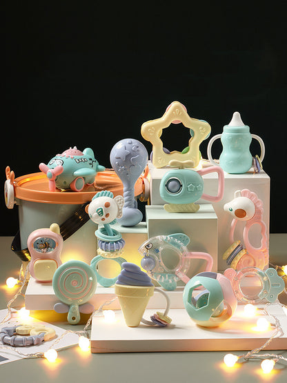 黒い背景に並べられたパステルカラーのベビーラトルセット全体
