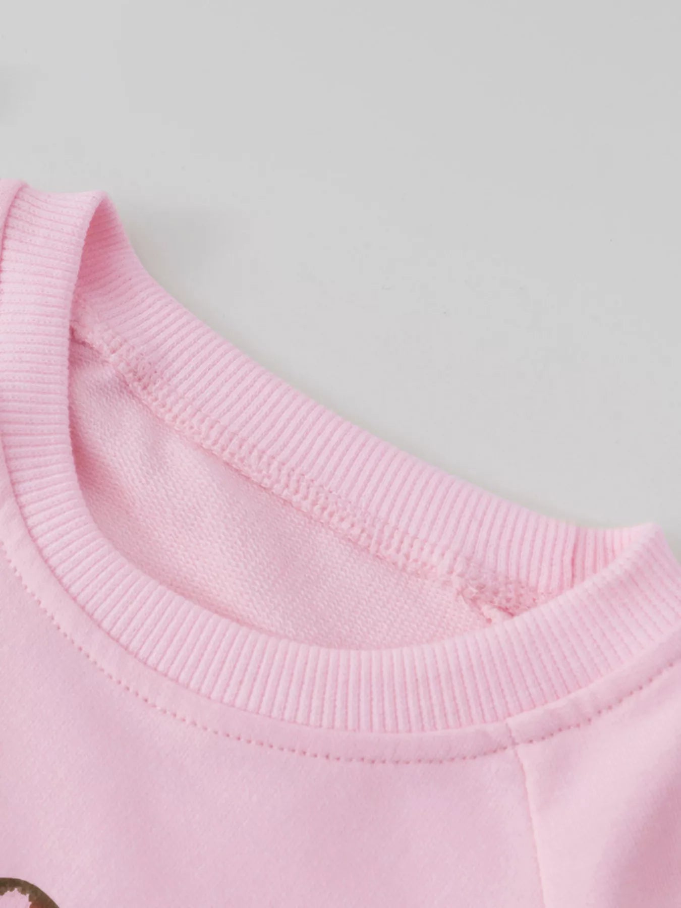 クルーネックまわりのステッチとリブが見える子ども用トップス首元ディテール
