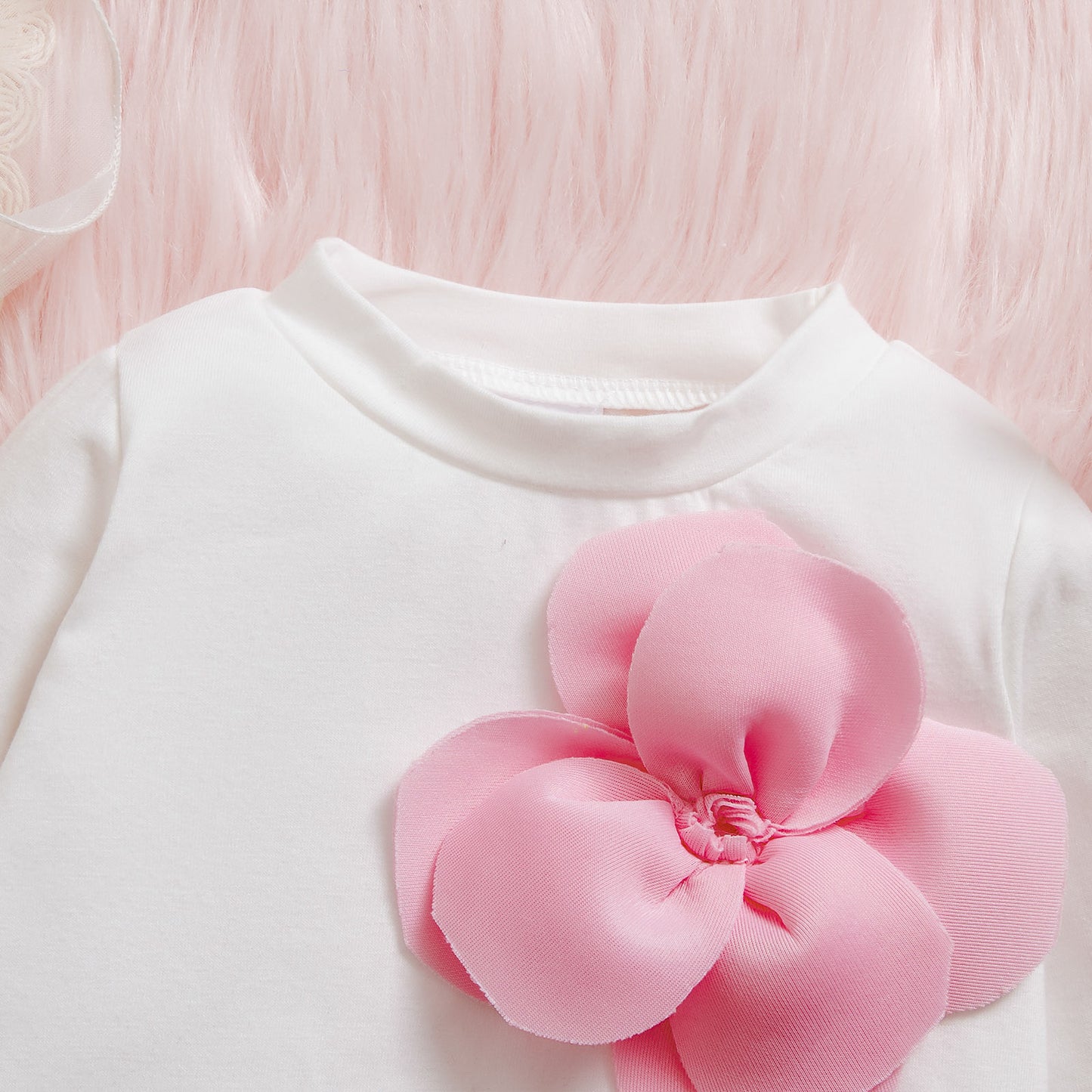 長袖トップスの花飾りデザインのクローズアップ
