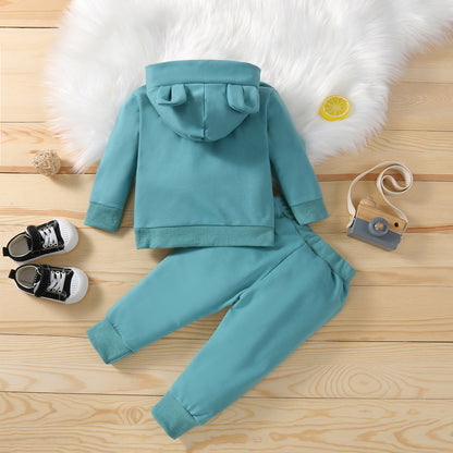 グリーンのフード付き長袖トップスとロングパンツの子どもニットセットアップをシューズ小物と一緒に並べた画像
