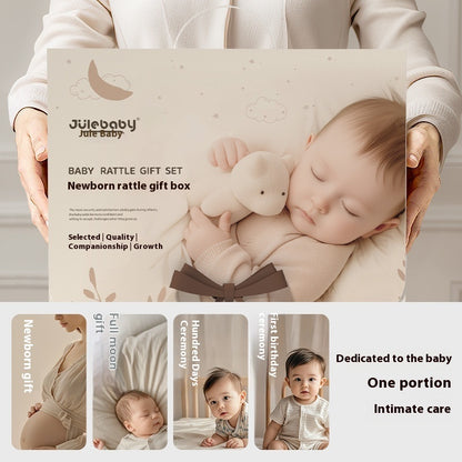眠る赤ちゃんのそばに置かれたベビーラトルギフトボックスのイメージ写真
