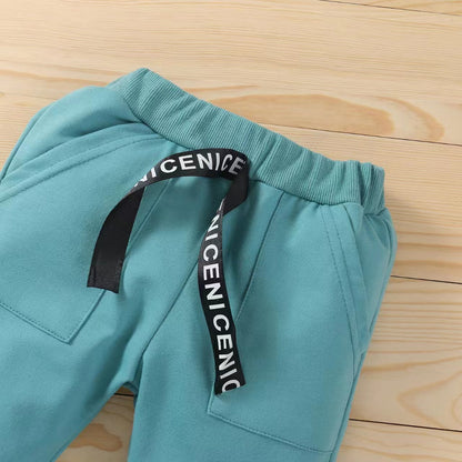 総ゴム仕様のウエストとロゴ入りテープが見えるグリーンロングパンツのウエストディテール
