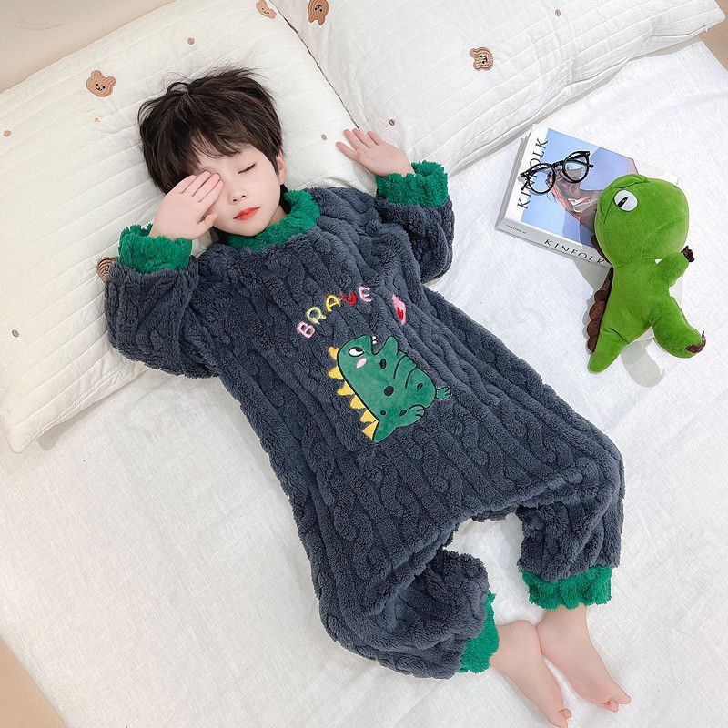 ベッドの上でくつろぐ男の子が着用するホワイト恐竜パジャマ
