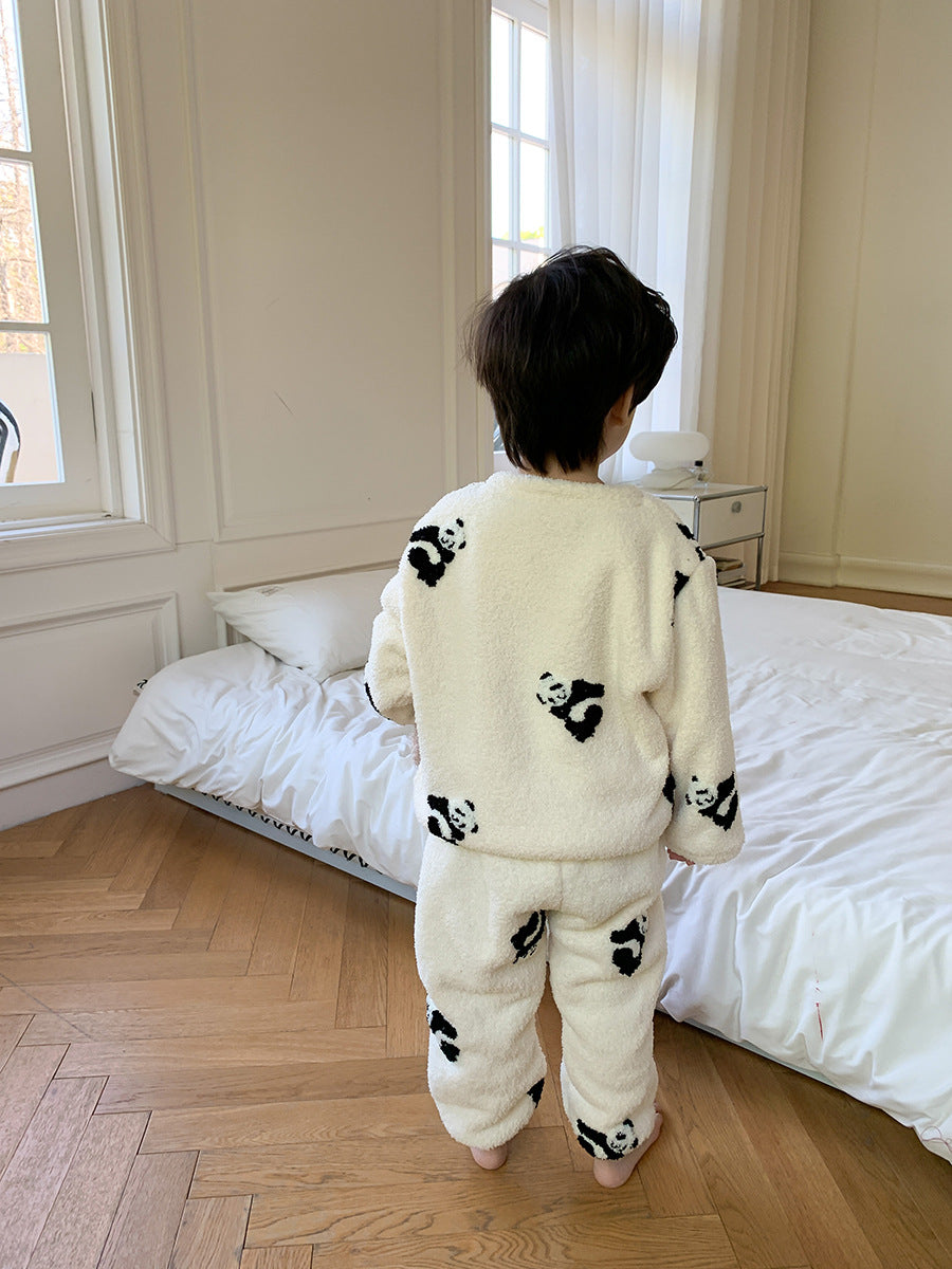 ベージュのもこもこパジャマ上下を着た子どもがベッドの前で後ろ向きに立っているバックスタイル
