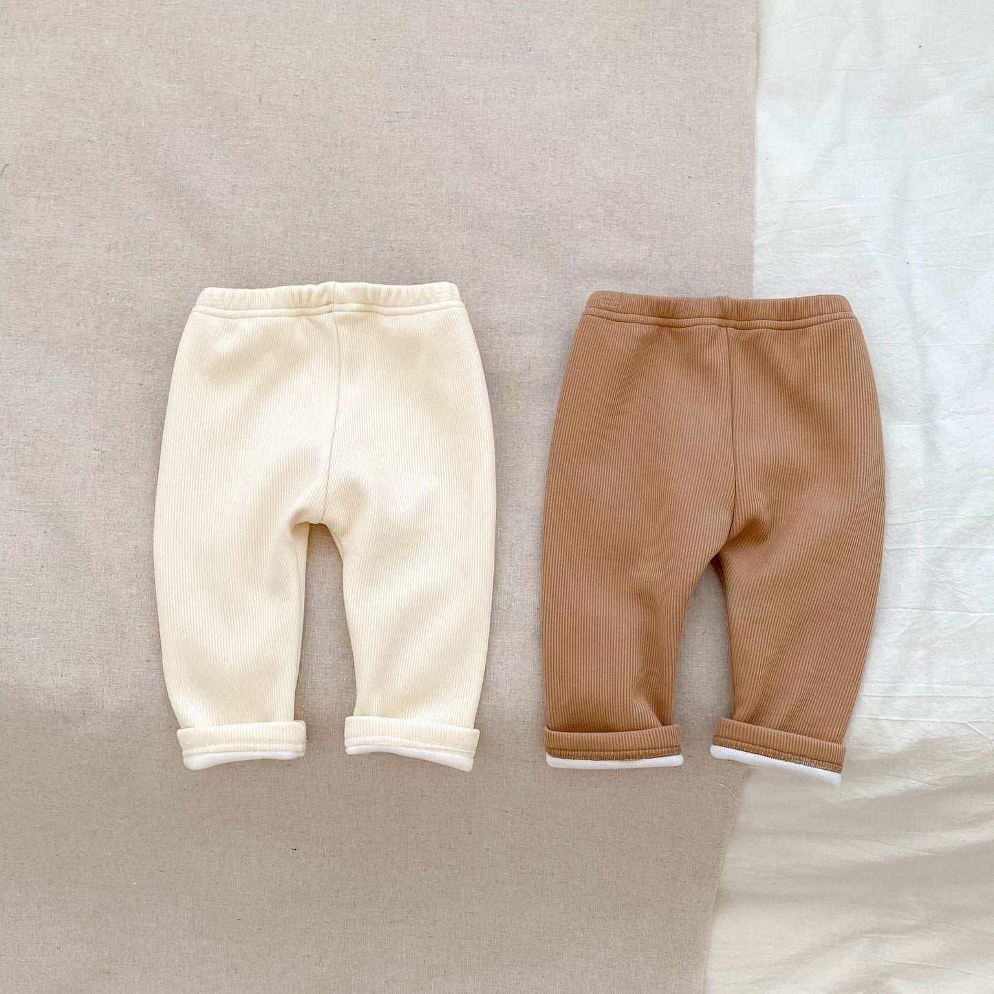 ミルクアプリコットカラーの男女兼用ベビーロングパンツを正面から撮影した画像
