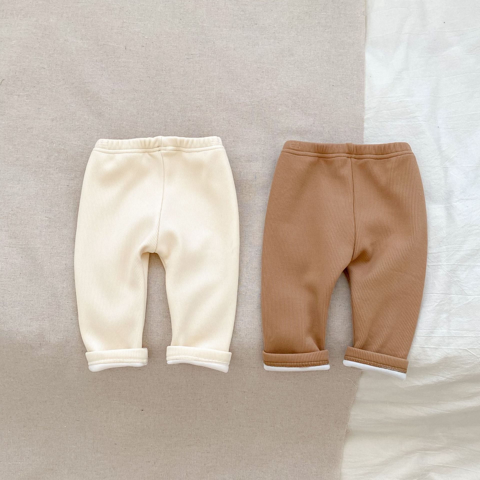 ミルクアプリコットカラーの男女兼用ベビーロングパンツを正面から撮影した画像
