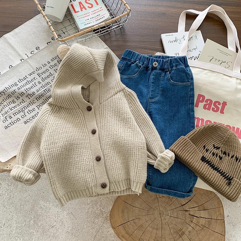 ナチュラルな小物と一緒にスタイリングした子どもカーディガンのフラットレイ
