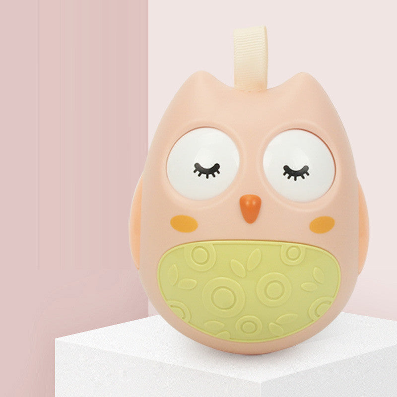 ピンクカラーのフクロウタンブラーラトルが少し斜めを向いて微笑んでいるように見えるアップ写真
