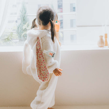 寝転んだ赤ちゃんに着せたうさぎフードジャンプスーツの着用イメージ
