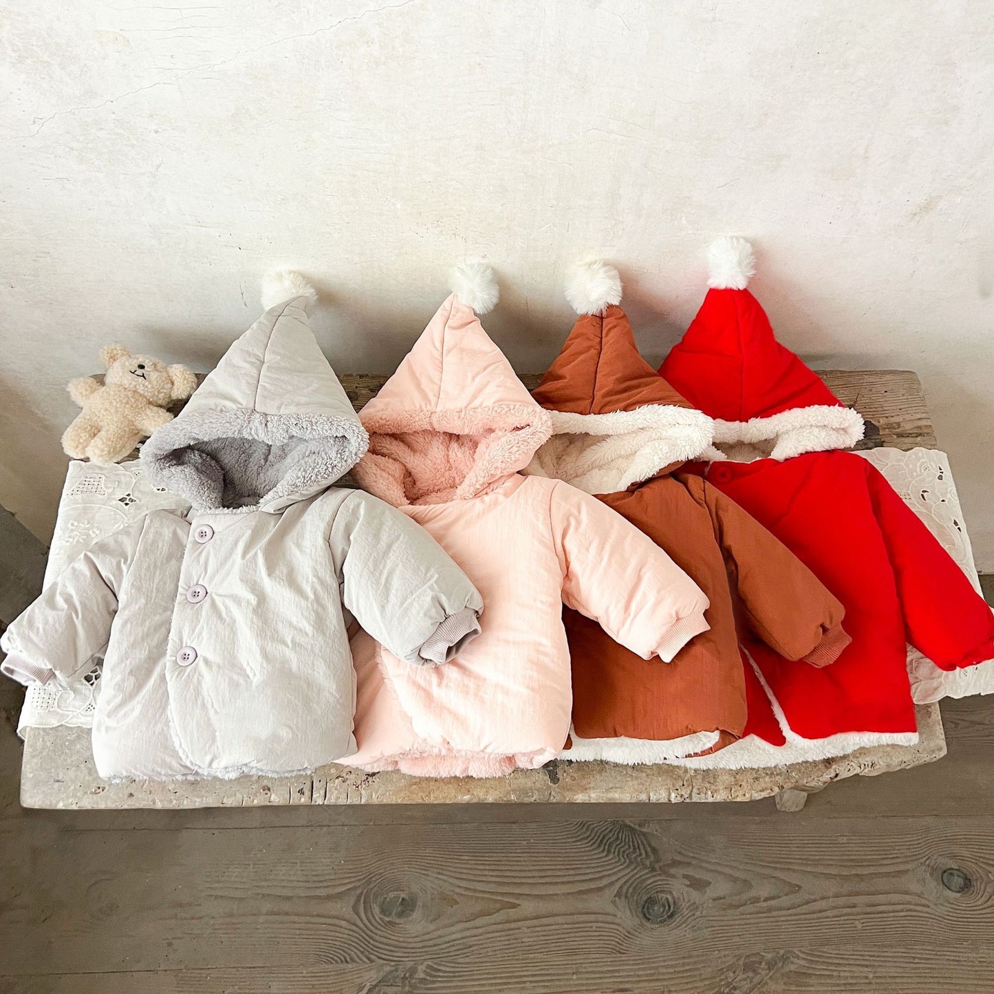 赤い無地ベビーコートのフードとボタン部分が見えるクローズアップ写真
