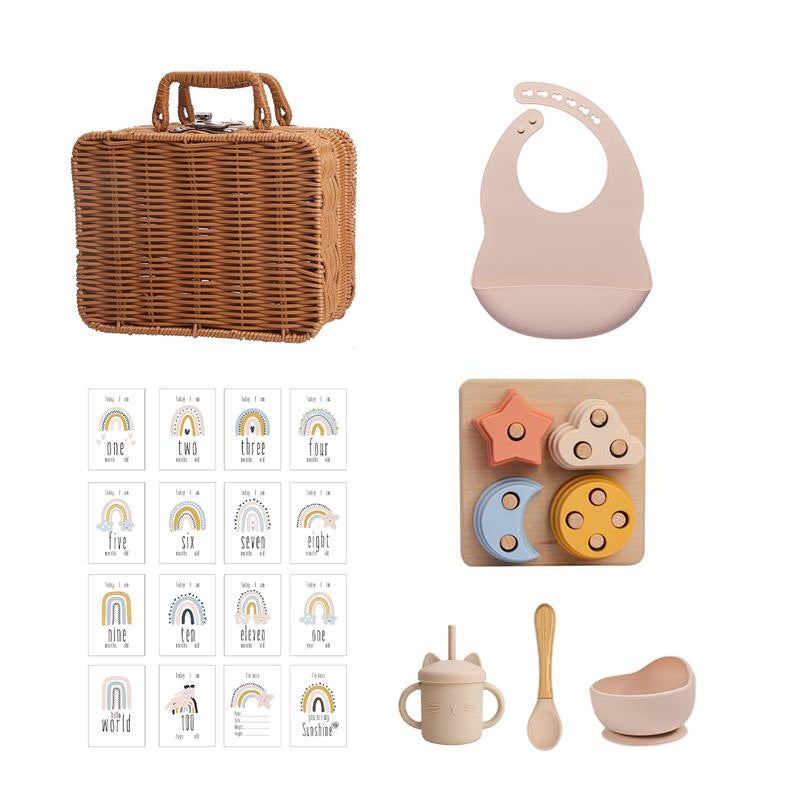 ラタン風バスケットとピンクのシリコンビブ、レインボーカード、星と月モチーフのスタッキングおもちゃ、ピンクのシリコンカップ＆ボウルが並んだセット画像（ベビー用シリコン知育＆テーブルウェアスーツ）
