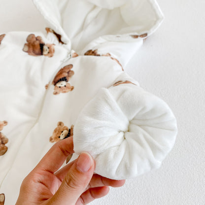 手に持ったベビーカバーオールの袖口からふわふわ裏地が見える、くま柄フリース裏地スリーブのディテールアップ
