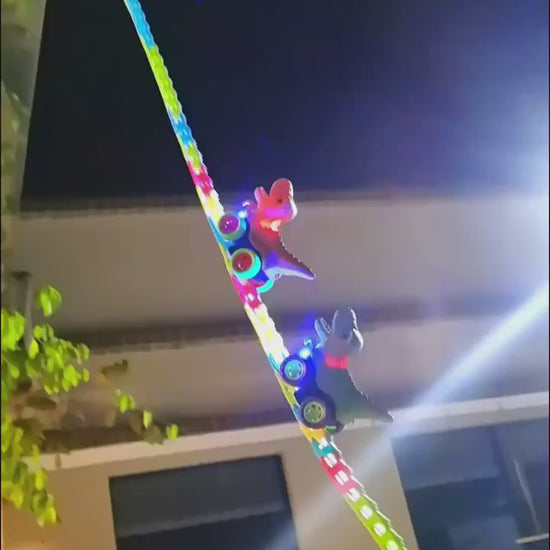 長いカラフルレールを壁に張り付けて恐竜カーが走っているローラーコースターおもちゃの全体写真
