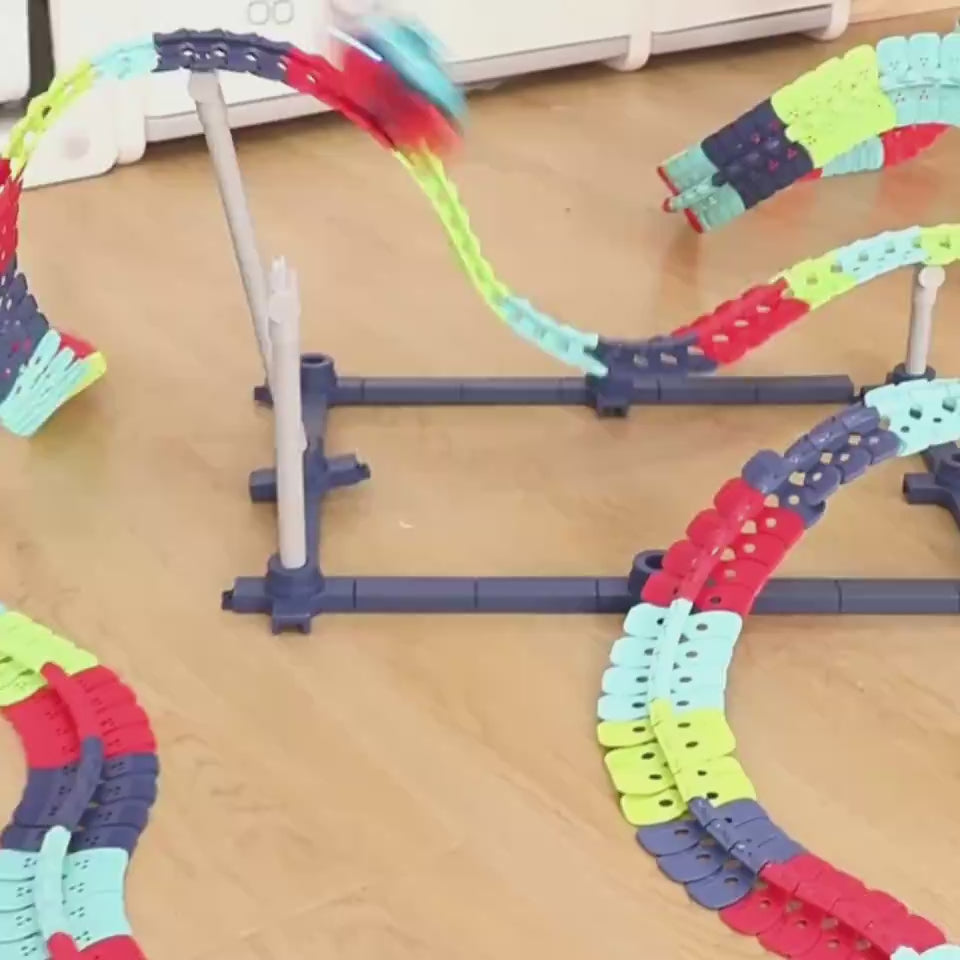 子どもが床に組んだカラフルレールを電動カーが登っていく動画サムネイル
