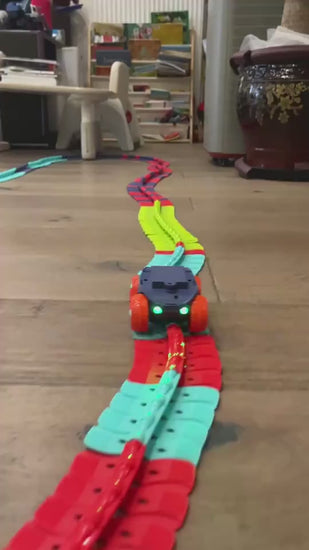 大人の手がフレキシブルレールパーツをつなぎ合わせてコースを組み立てている動画サムネイル
