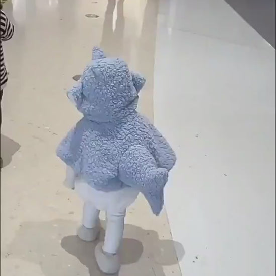 室内で子どもがサメフード付きケープを着て歩く様子が分かる後ろ姿
