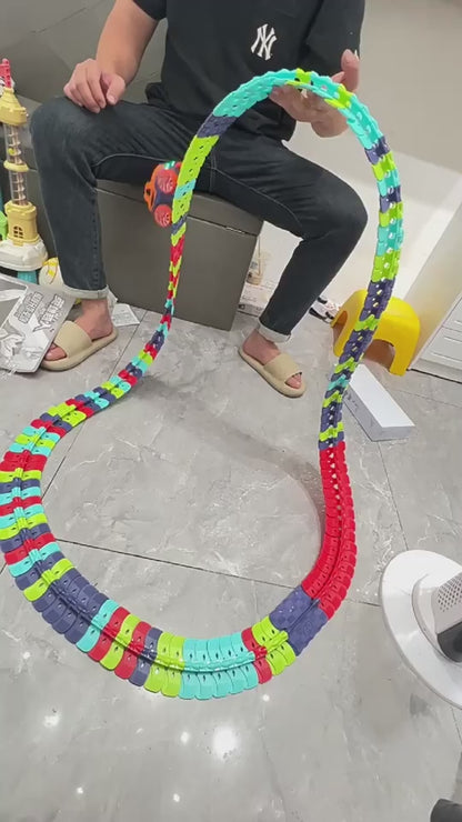 大人の手がフレキシブルレールパーツをつなぎ合わせてコースを組み立てている動画サムネイル
